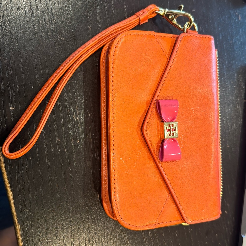 Tory Burch orange wallet wristlet with pink bow.